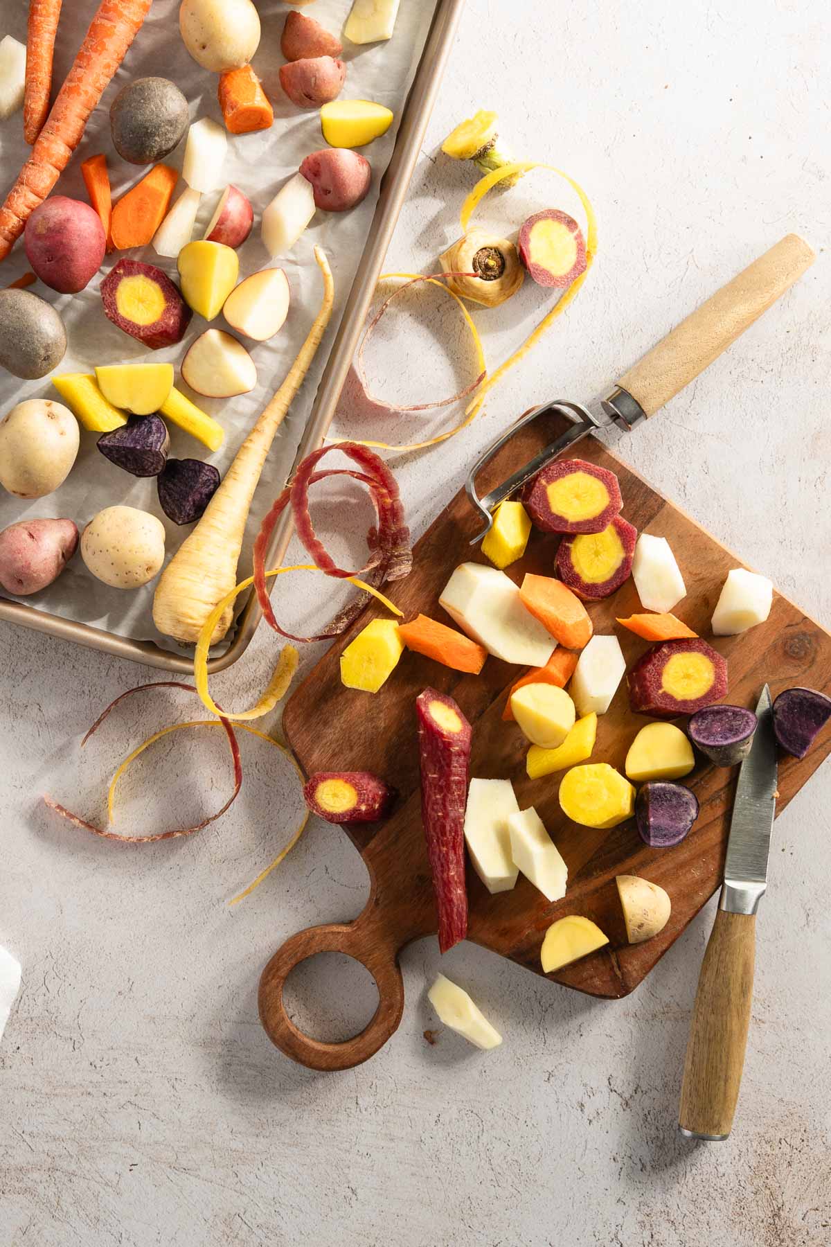 veggies on a cutting board, small knife, veggie peeler