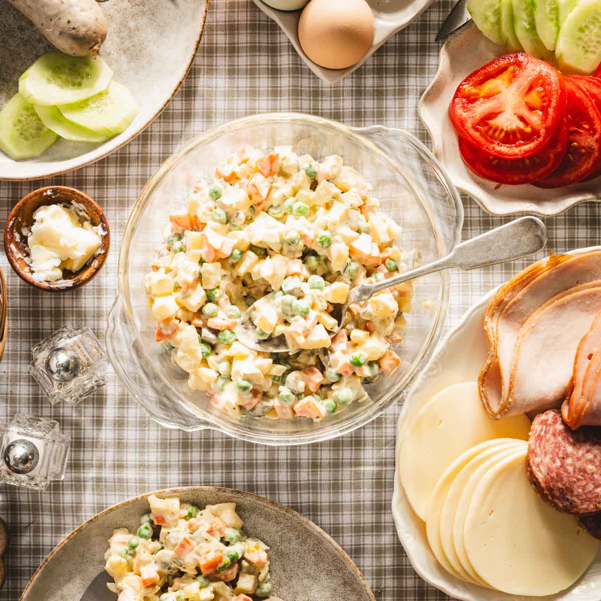 salad in a glass dish, various plates with other food, veggies, meats, etc