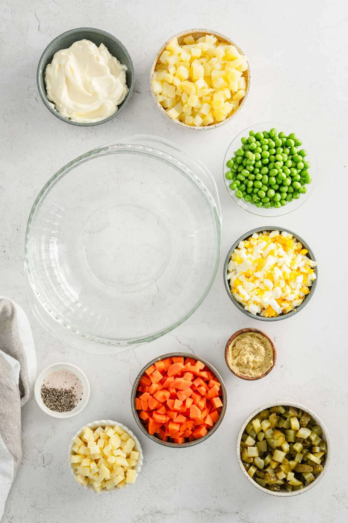 glass bowl, ingredients to make salatka placed around
