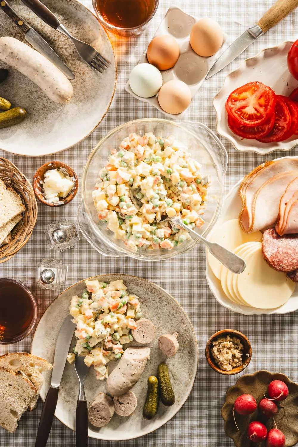 salad in a glass dish, various plates with other food, veggies, meats, etc