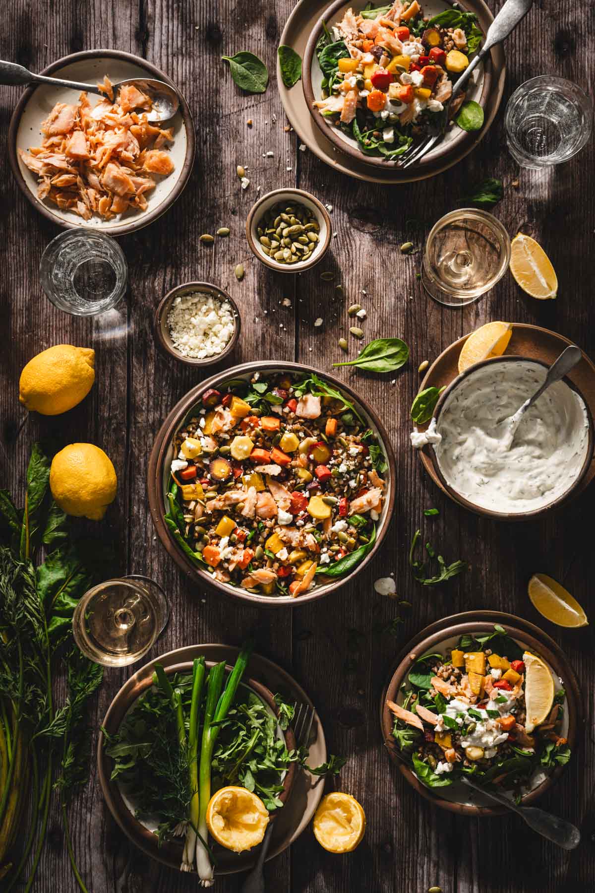 large serving bowl with the salad, other plates with the salad, fresh lemons