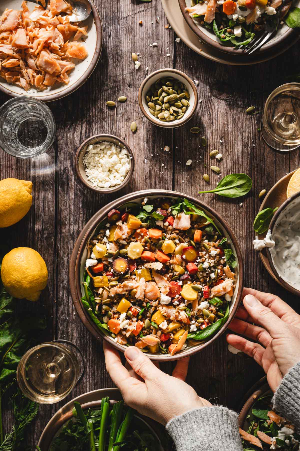 hands in frame around the bowl with the salad