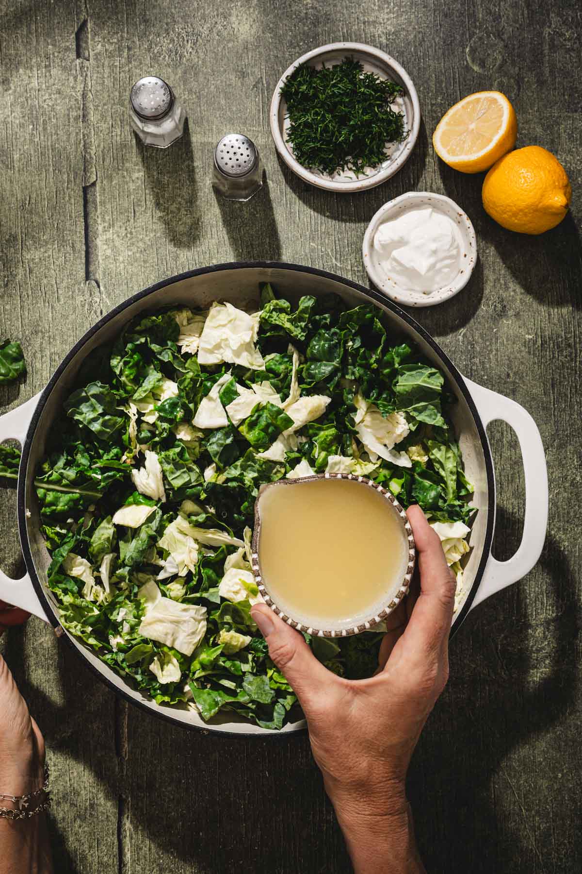 hands in frame adding broth