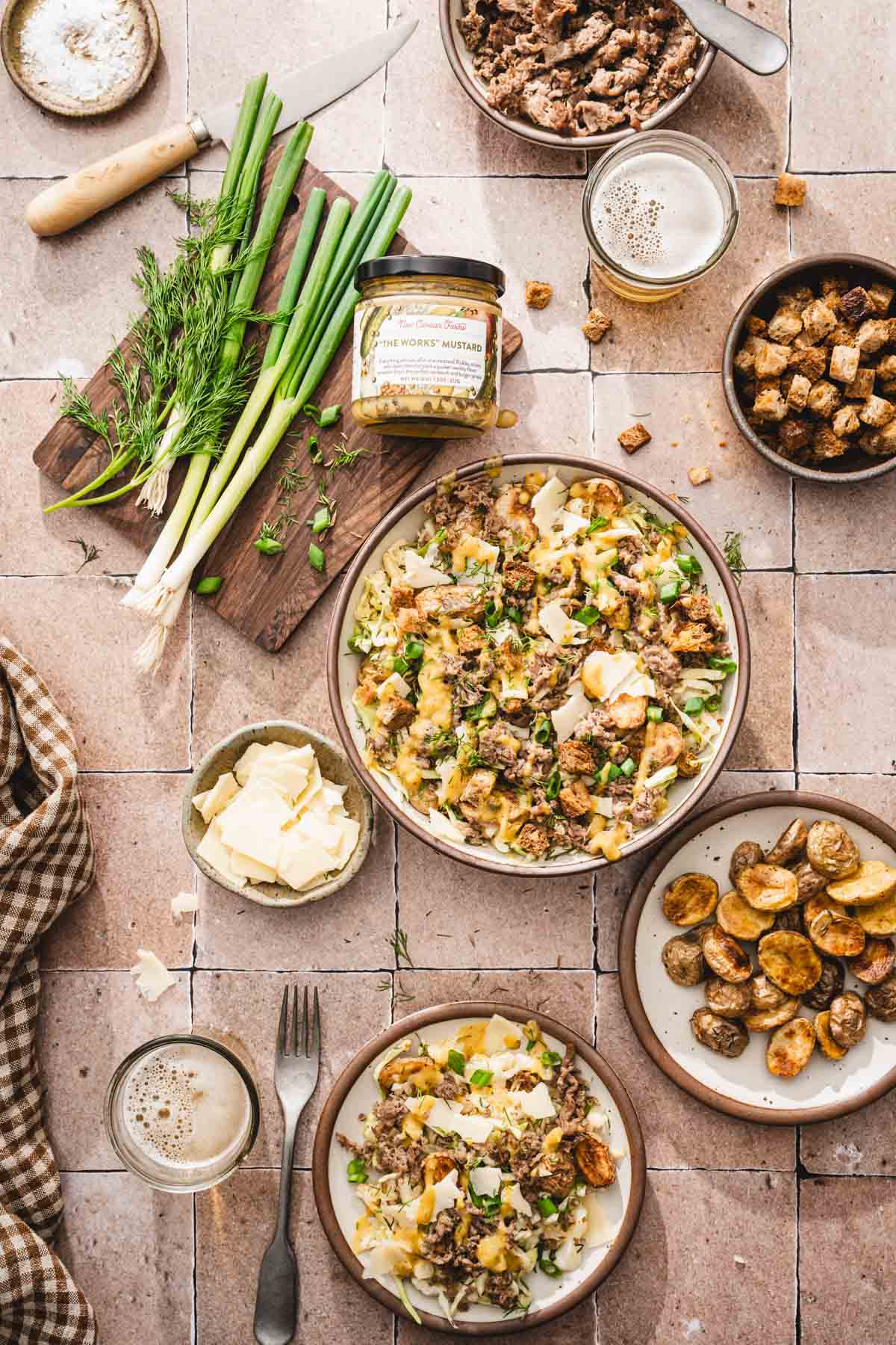 various serving plates and bowls with the salad, jar with the mustard