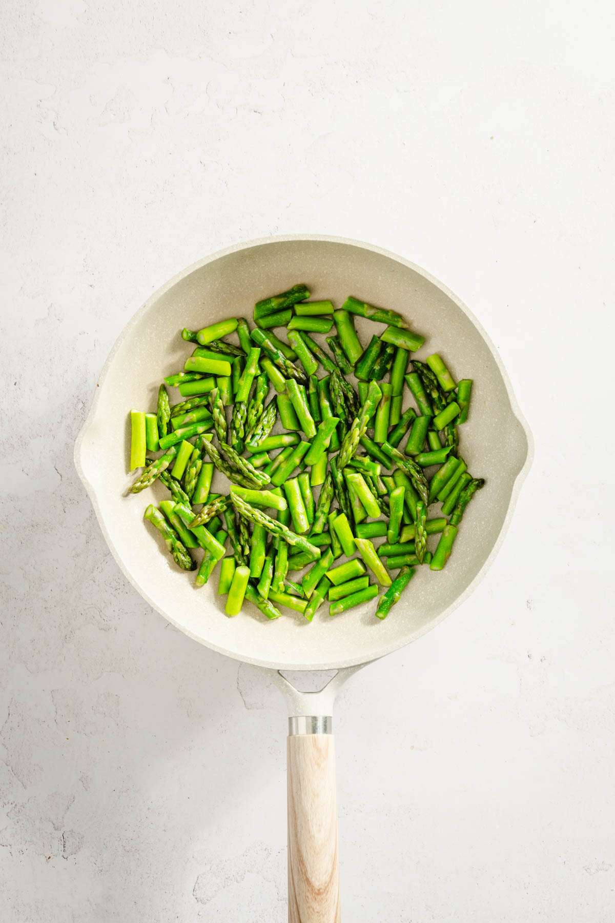 raw, chopped asparagus on a skillet