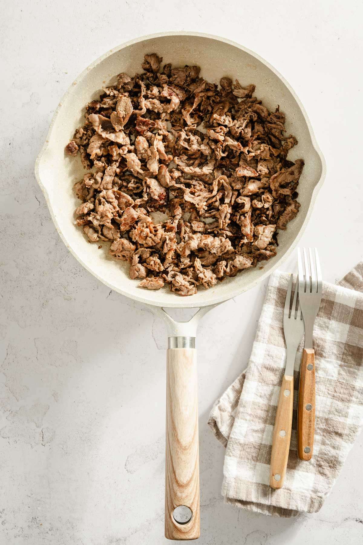 cooked shaved beef on a frying pan