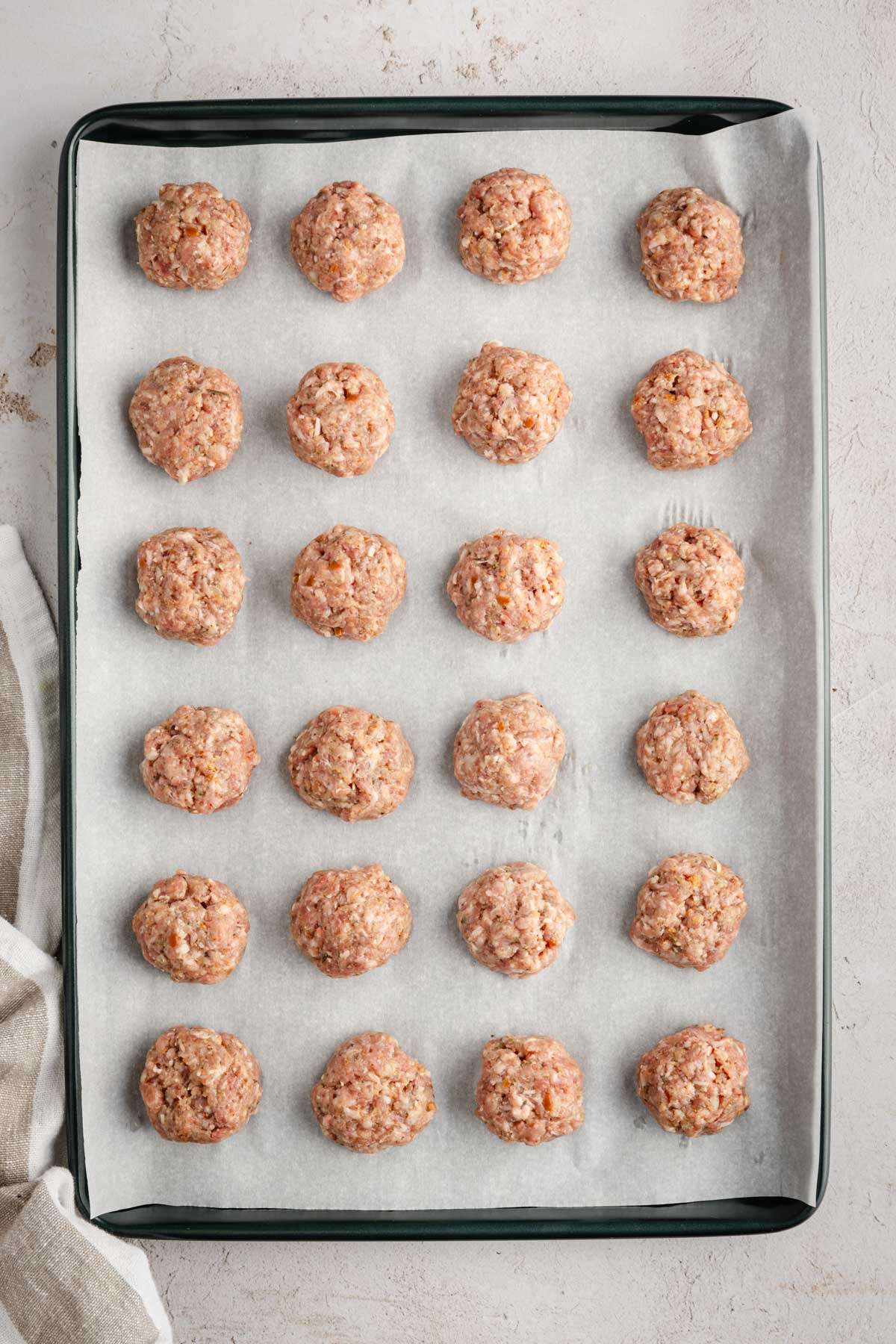 meatballs formed on a baking sheet, ready for cooking