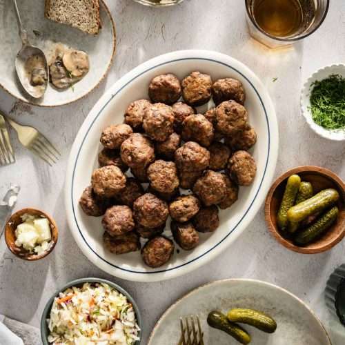 Meatballs on a serving platter; small side dishes around