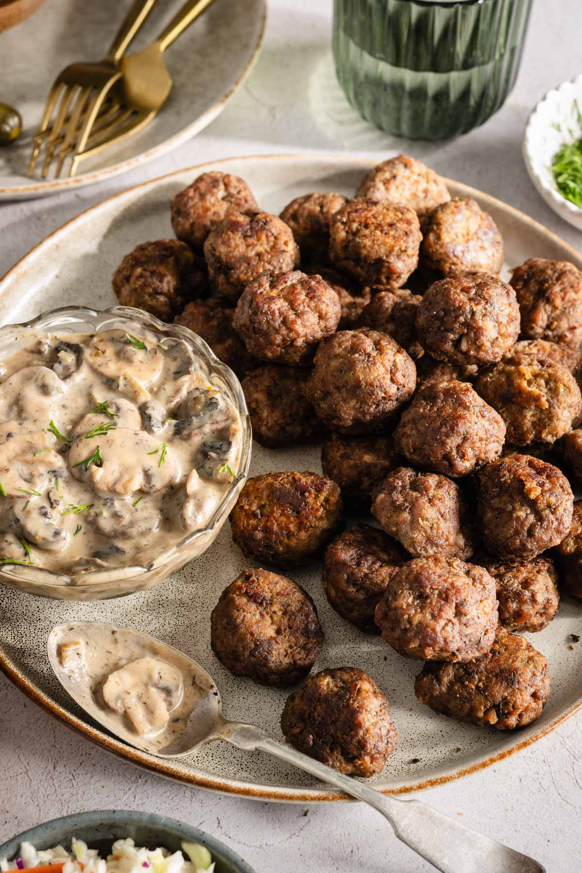 Meatballs on a serving platter; small side dishes around