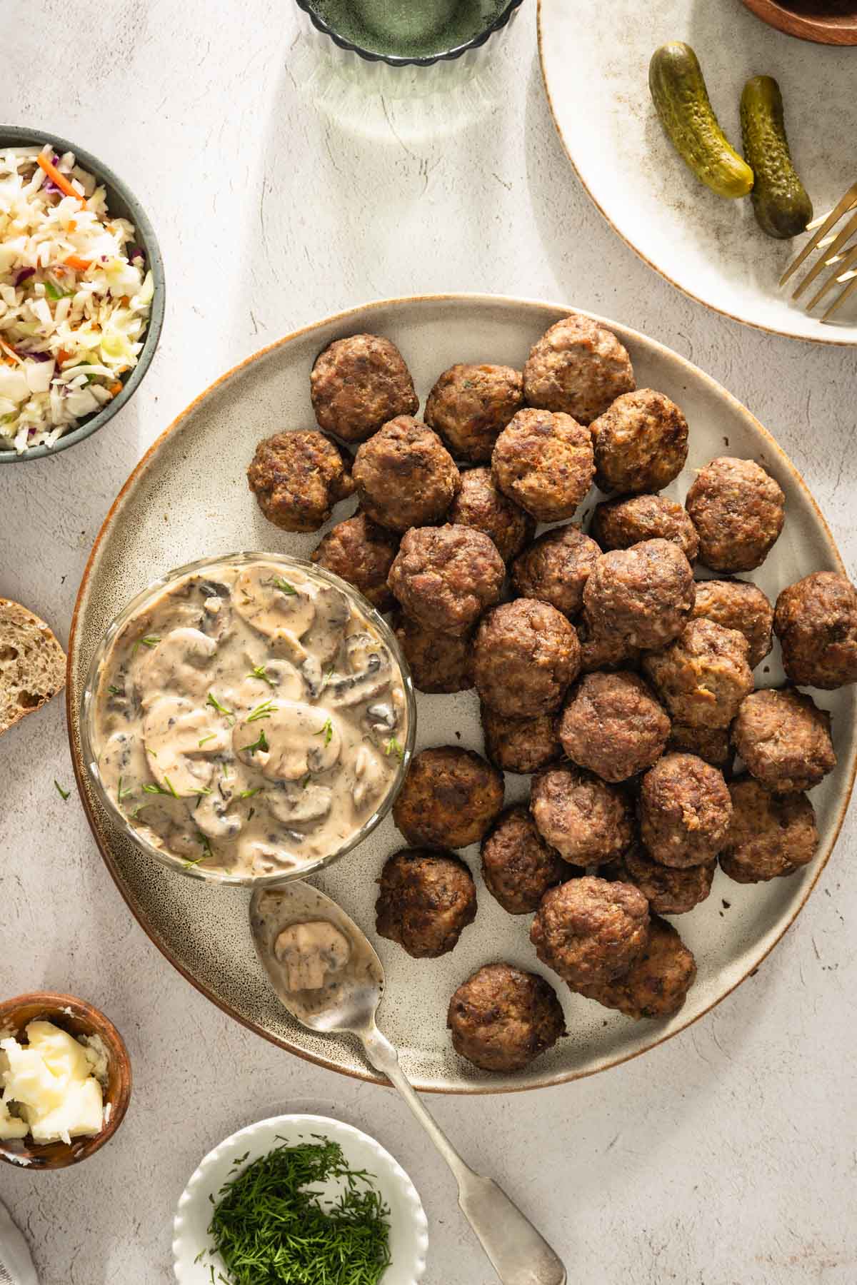 Meatballs on a serving platter; small side dishes around