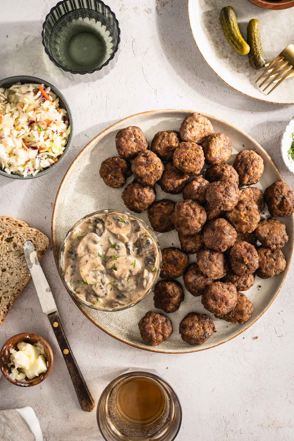 Meatballs on a serving platter; small side dishes around