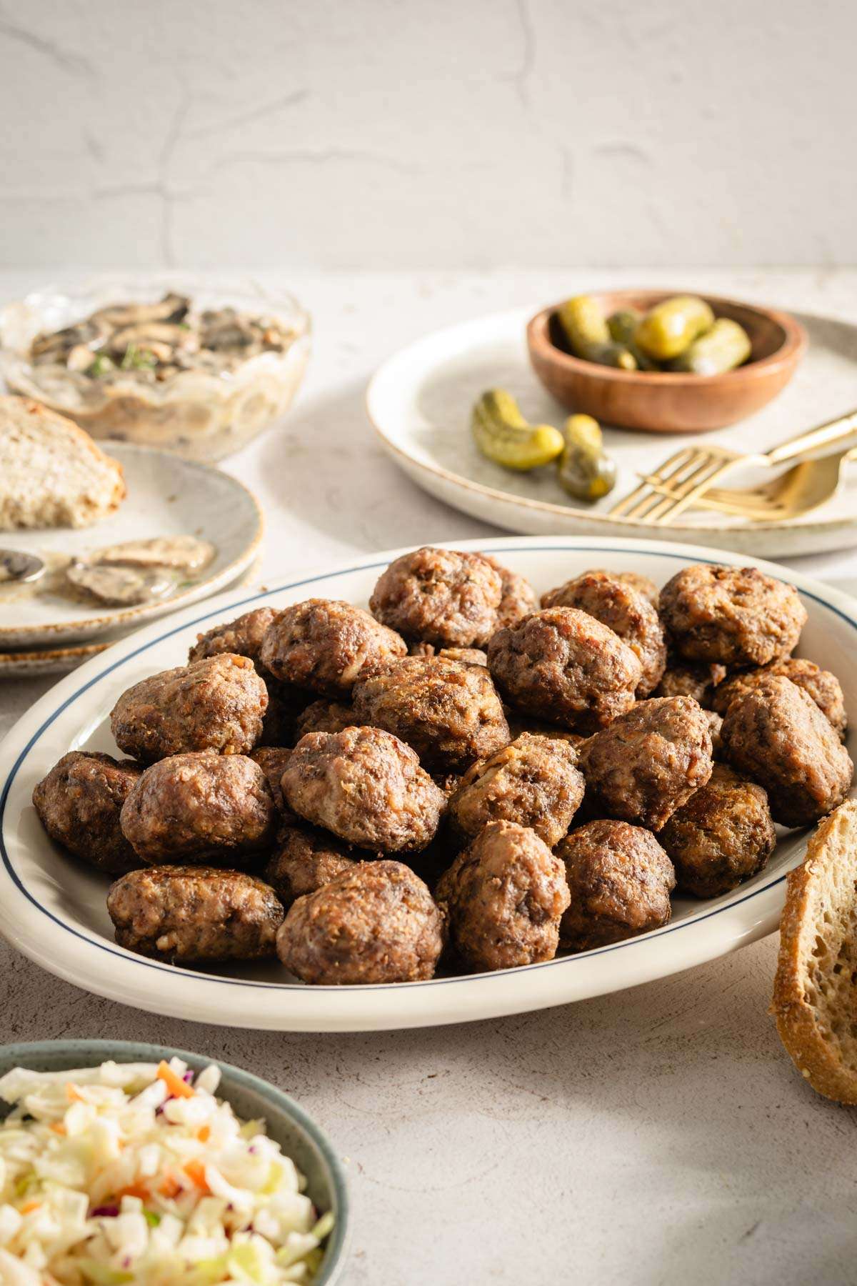 Meatballs on a serving platter; small side dishes around