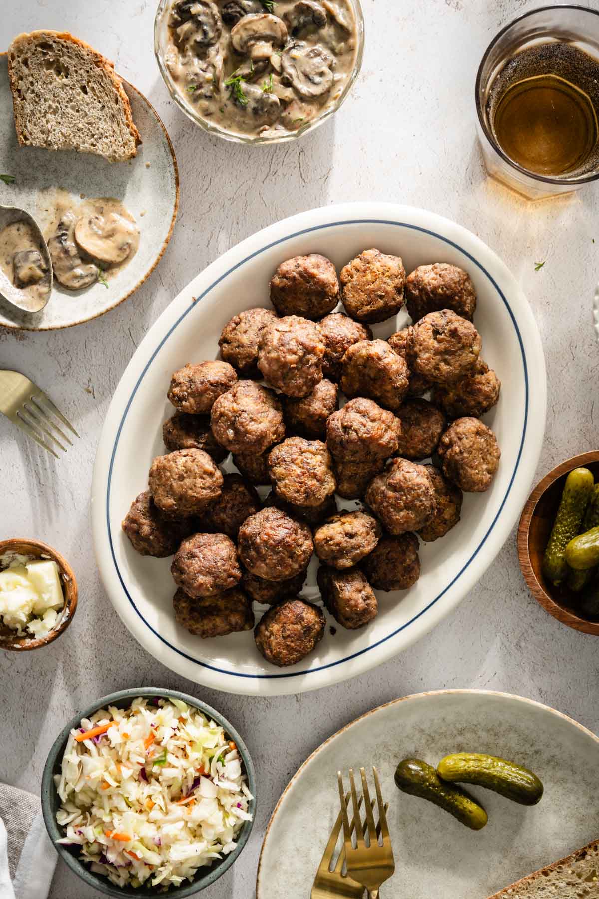 Meatballs on a serving platter; small side dishes around