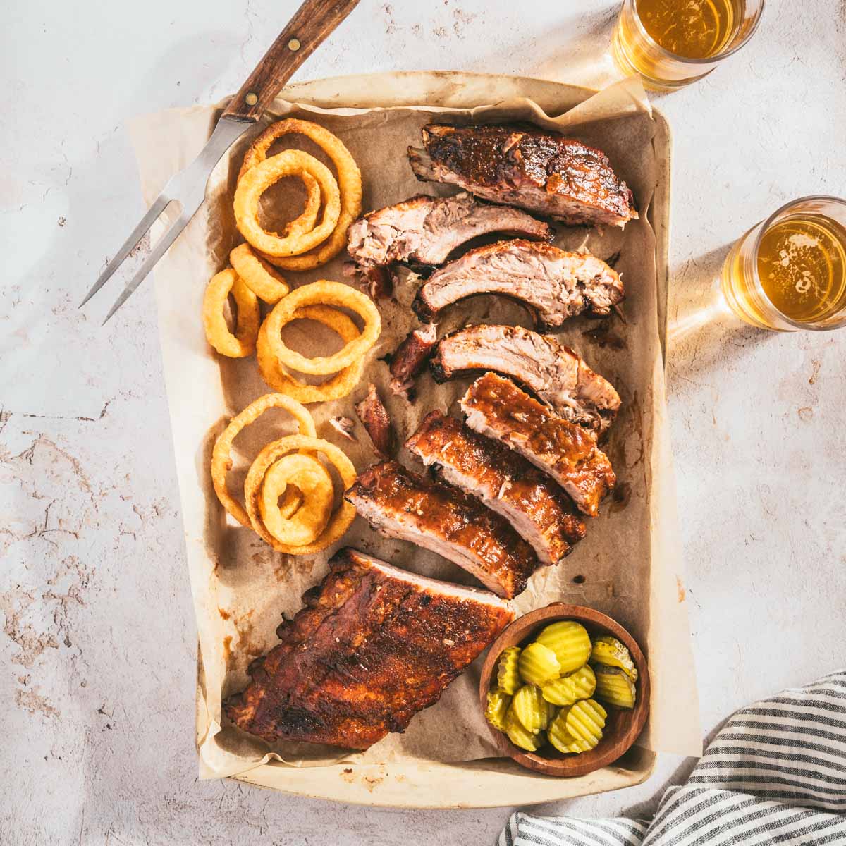 smoked ribs, cut into pieces, glass with beer, pickles