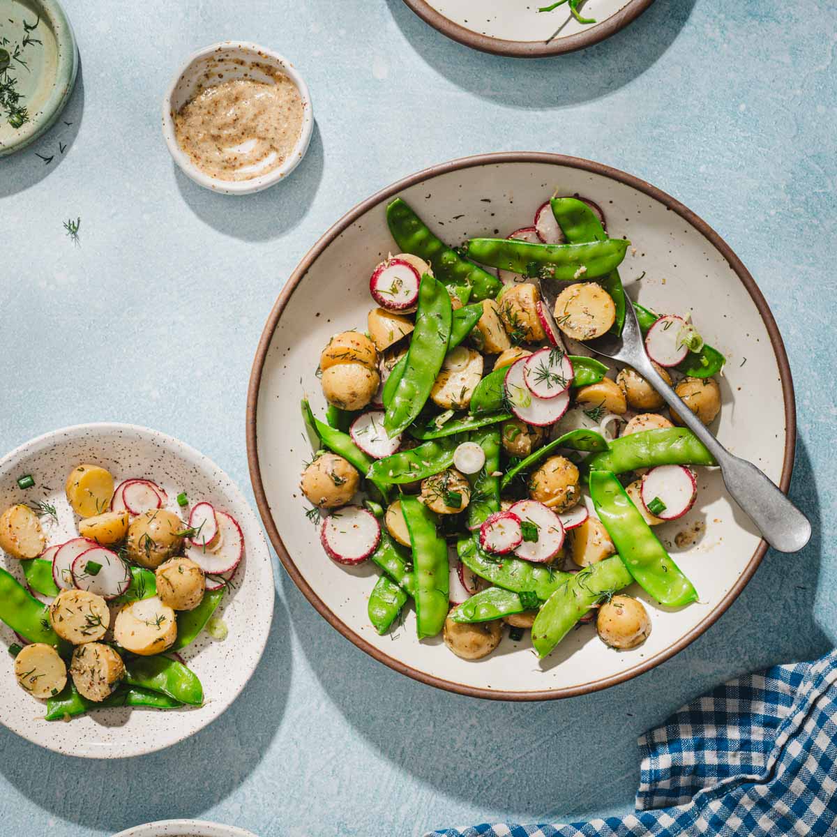 snow pea slaad in a serving bowl, other small plates