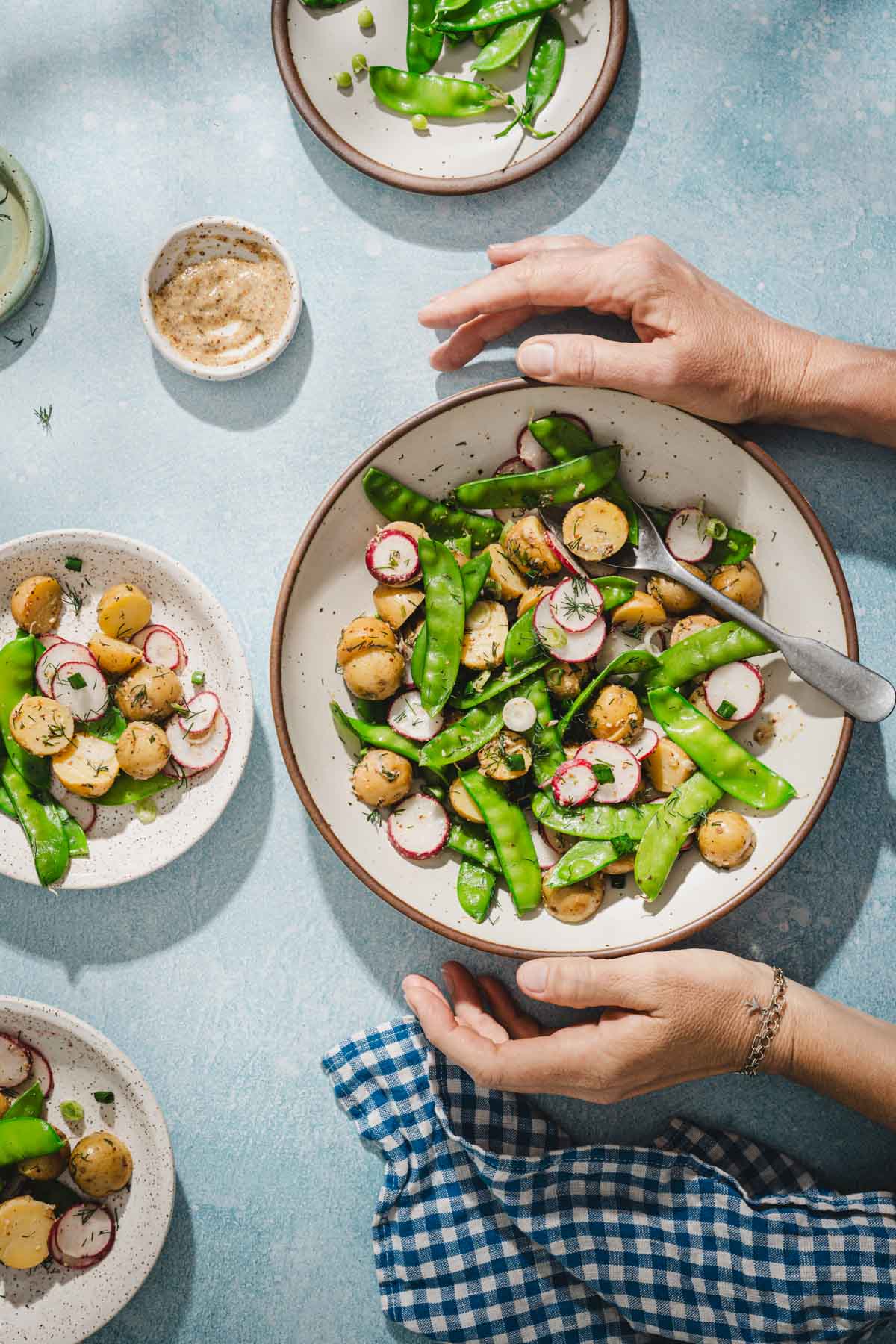 hands in frame holding a bowl with snow pea salad