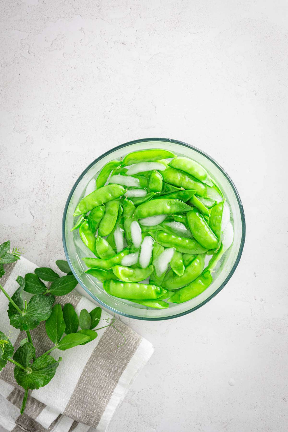 snow peas with a bowl with ice water