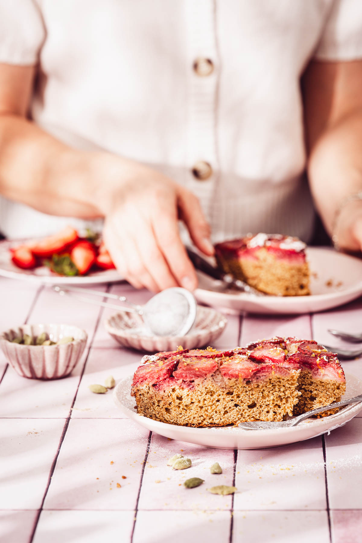 person in the frame, sittign at the table with the cake