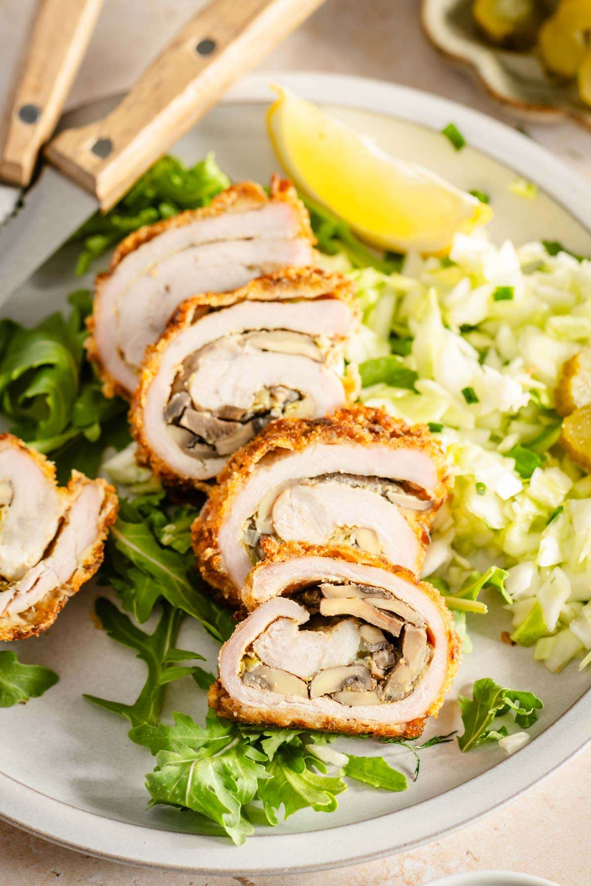 close up of cut stuffed pork chop on a plate with salad