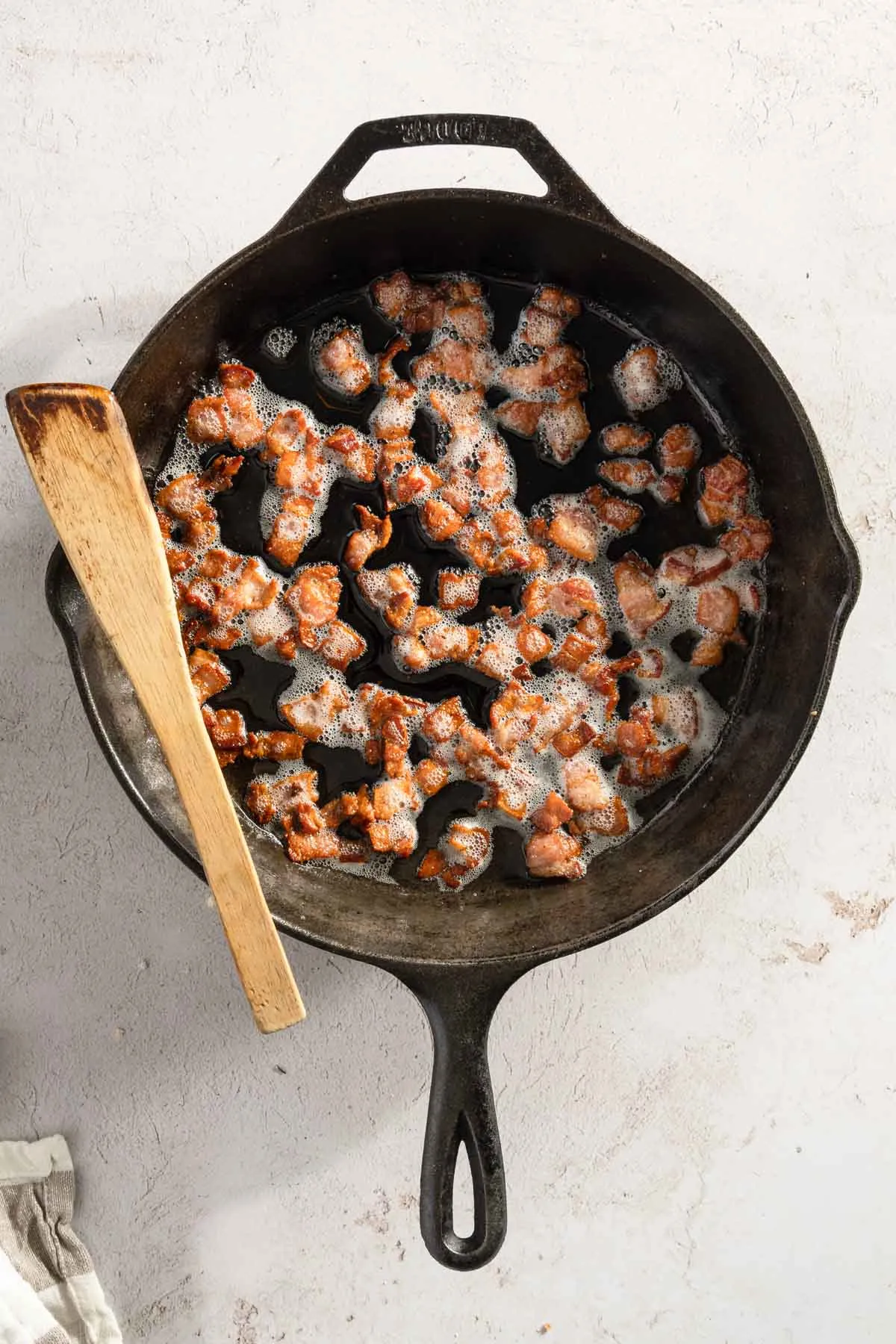 cooked bacon bits in a cast iron pan