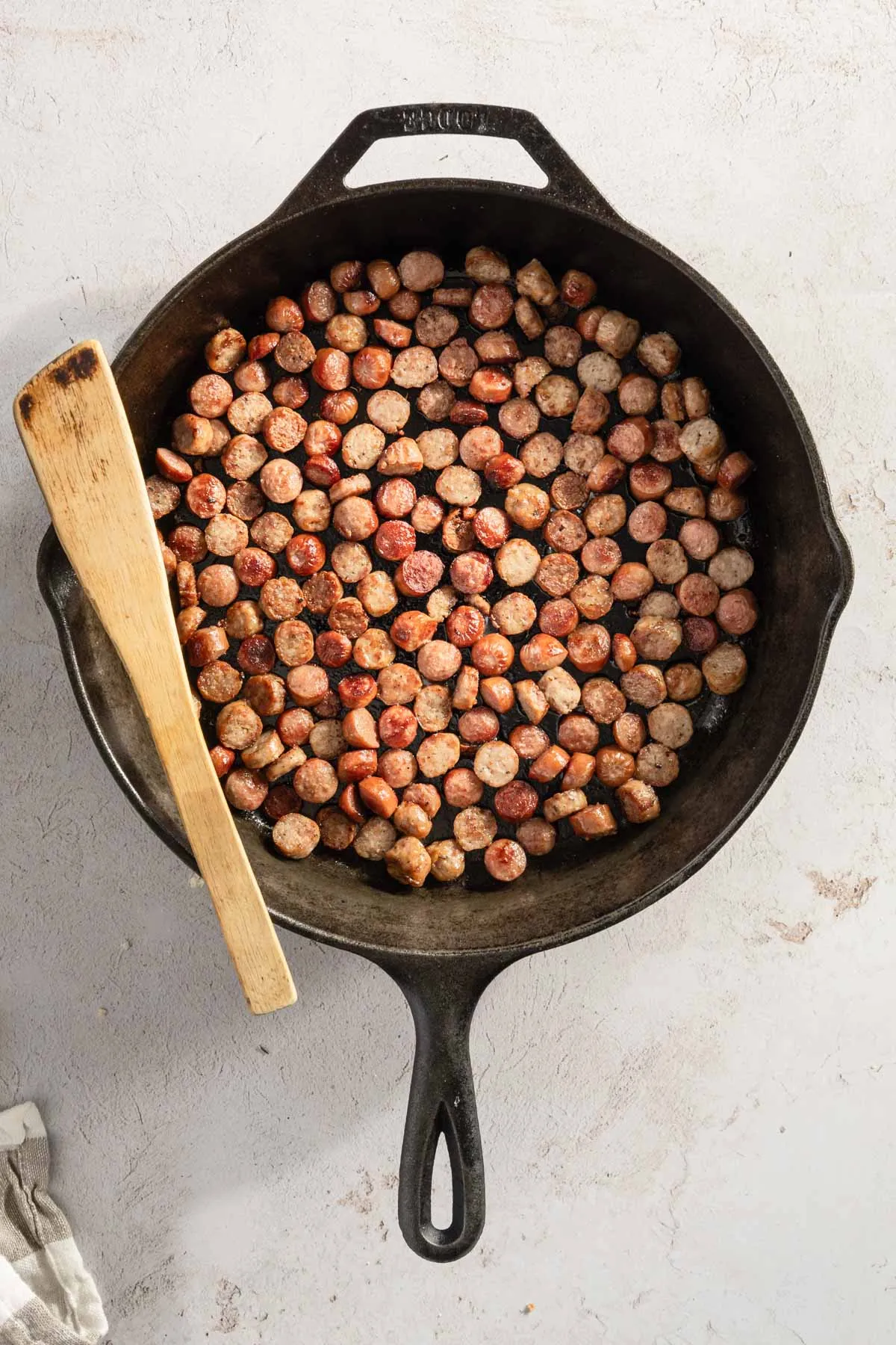cut up, cooked sausage in a cast iron pan