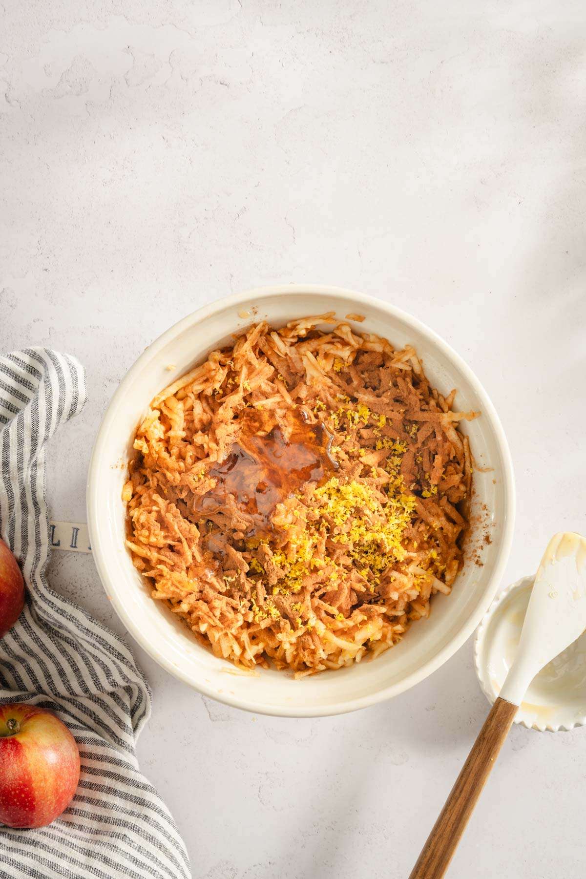 shredded apples in a bowl with other ingredients added