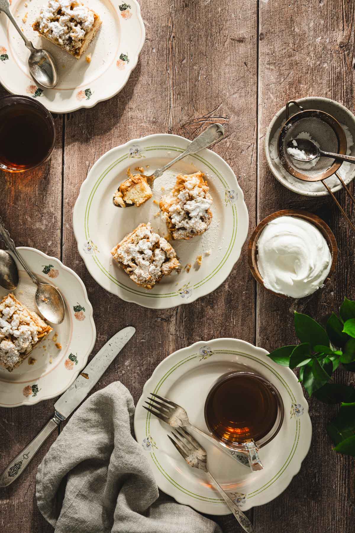 zarlotka on serving plates, tea, bowl with powdered sugar, bowl with whipped toppin