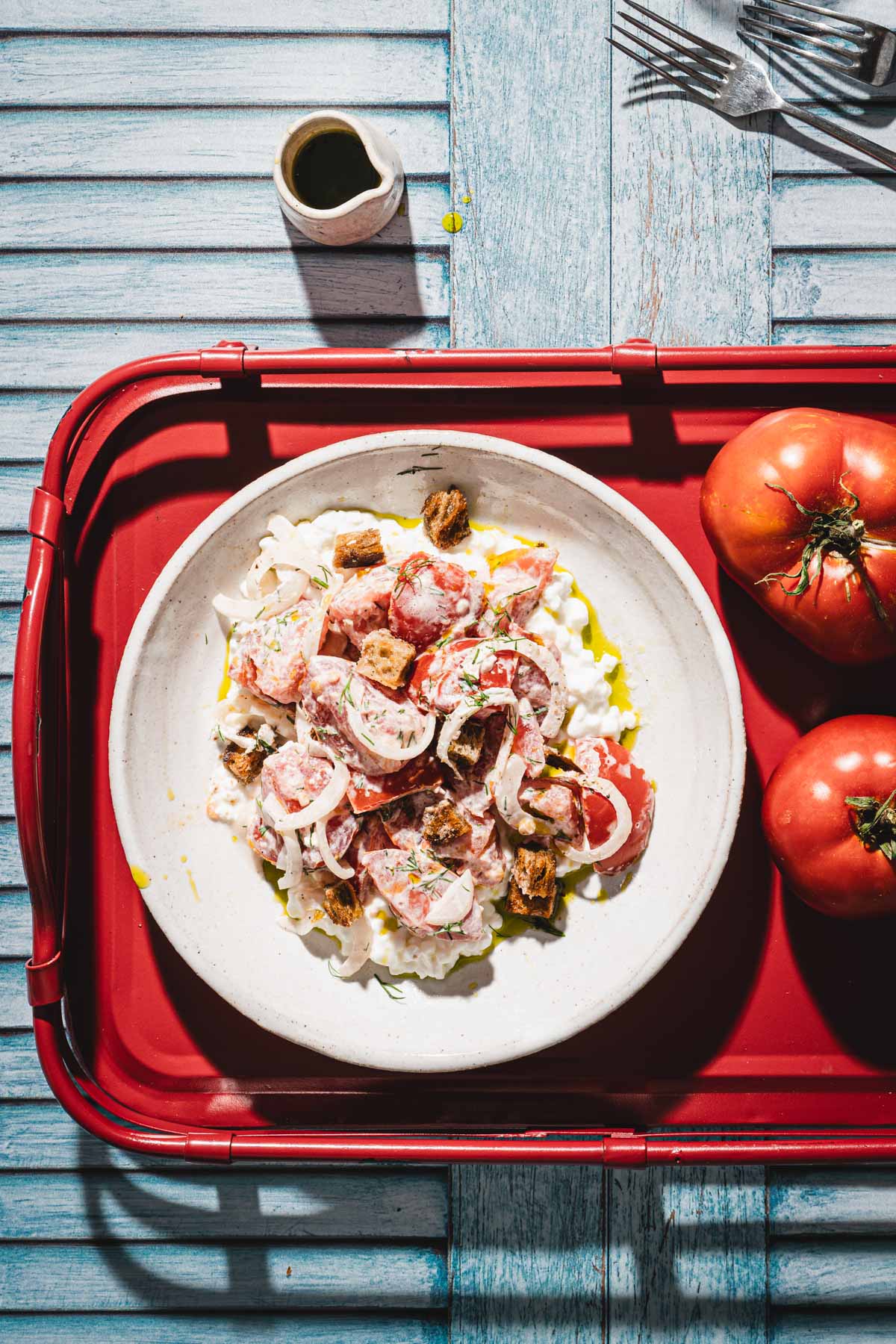 deep plate with the salad, two tomatoes, glasses with water