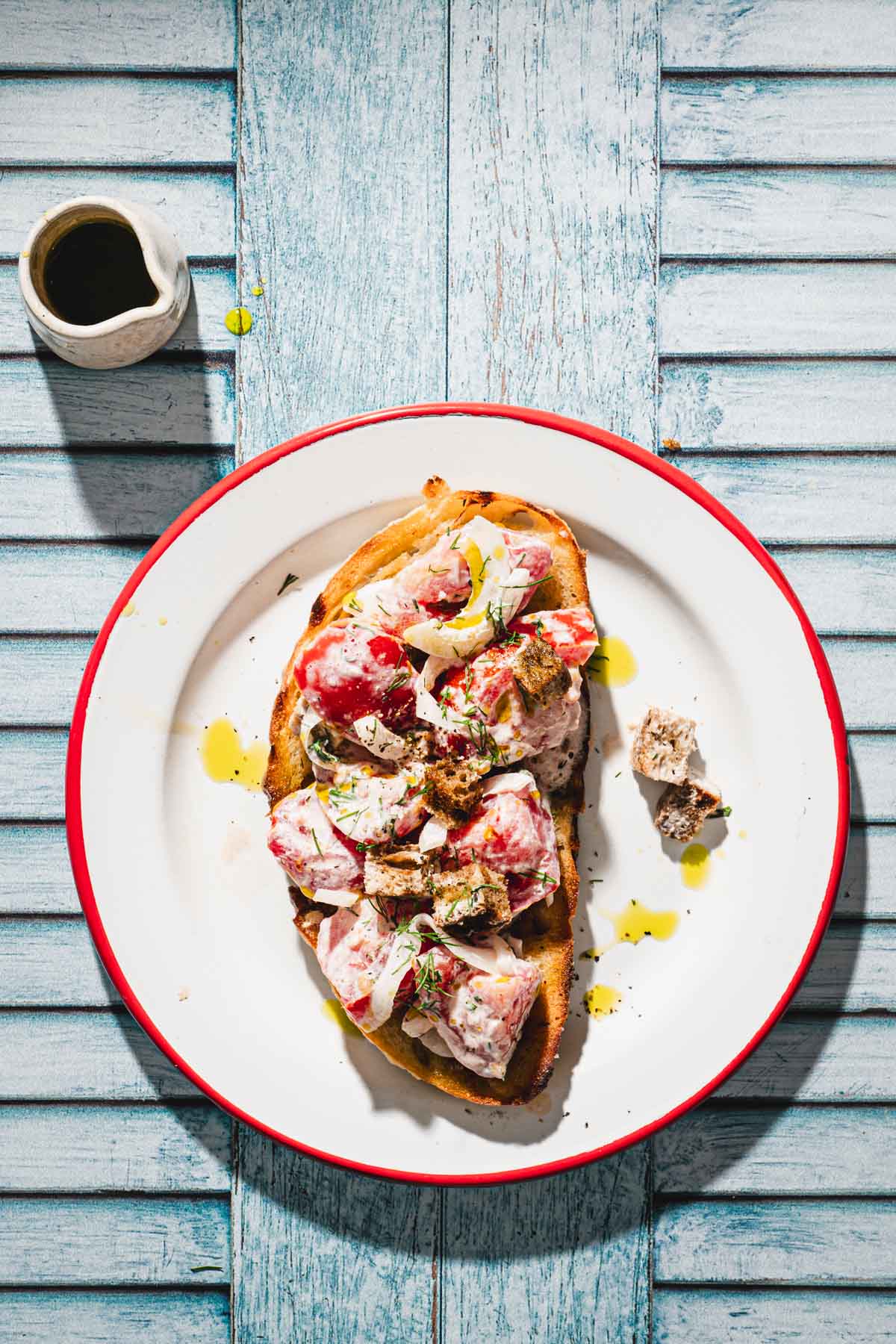 plate with a piece of bread and tomato salad