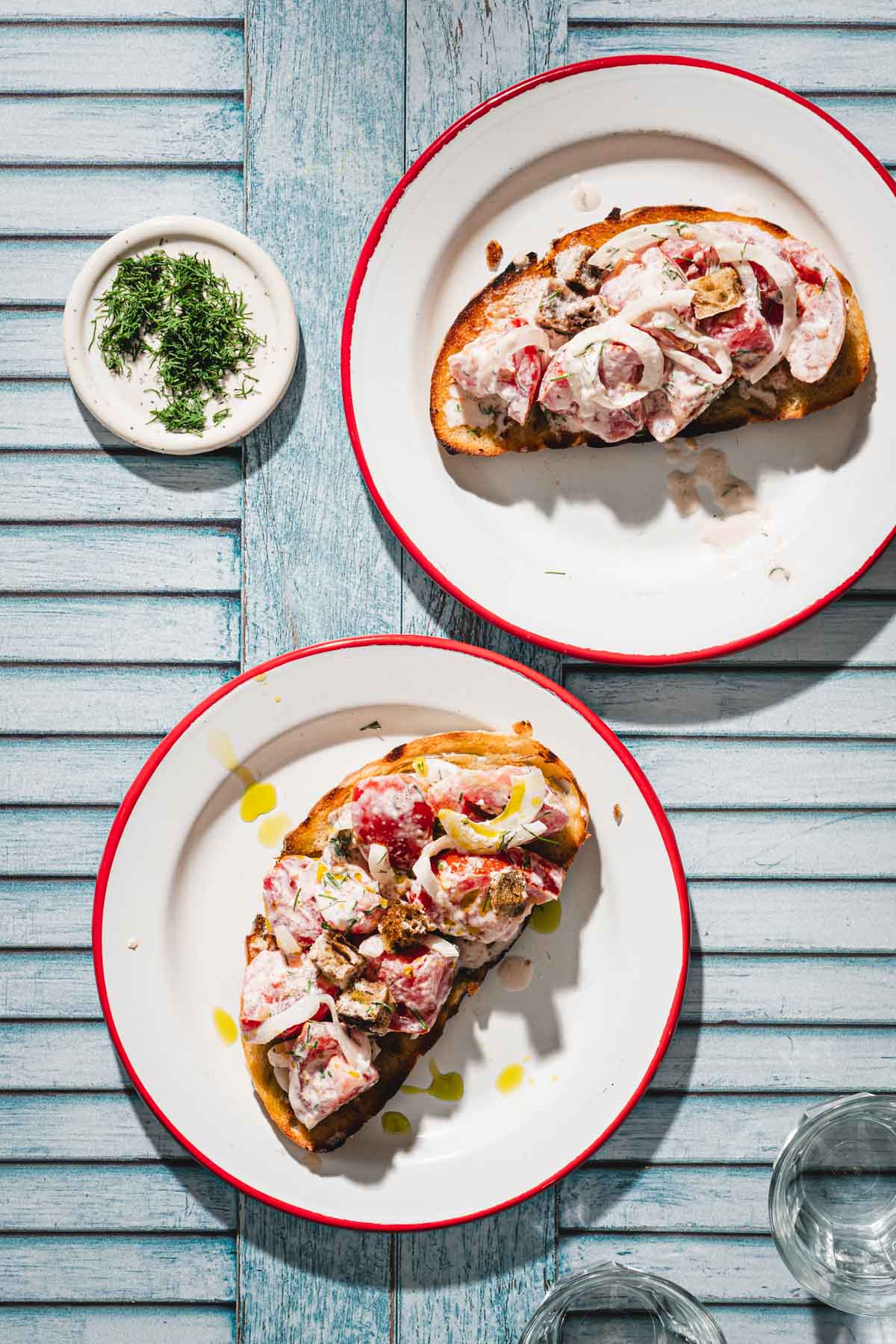 two plates with toasted bread topped with the salad