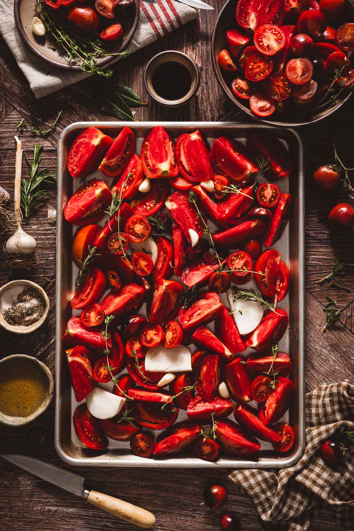 cut up tomatoes on a rimmed sheet