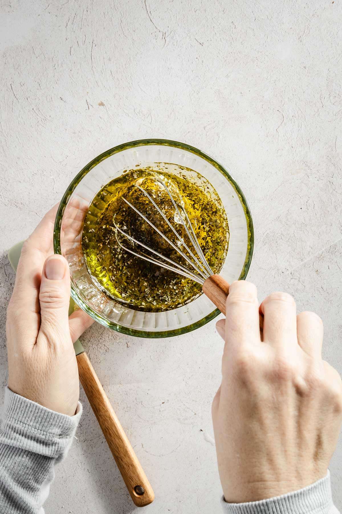 hands in frame mixing the vinaigrette ingredients