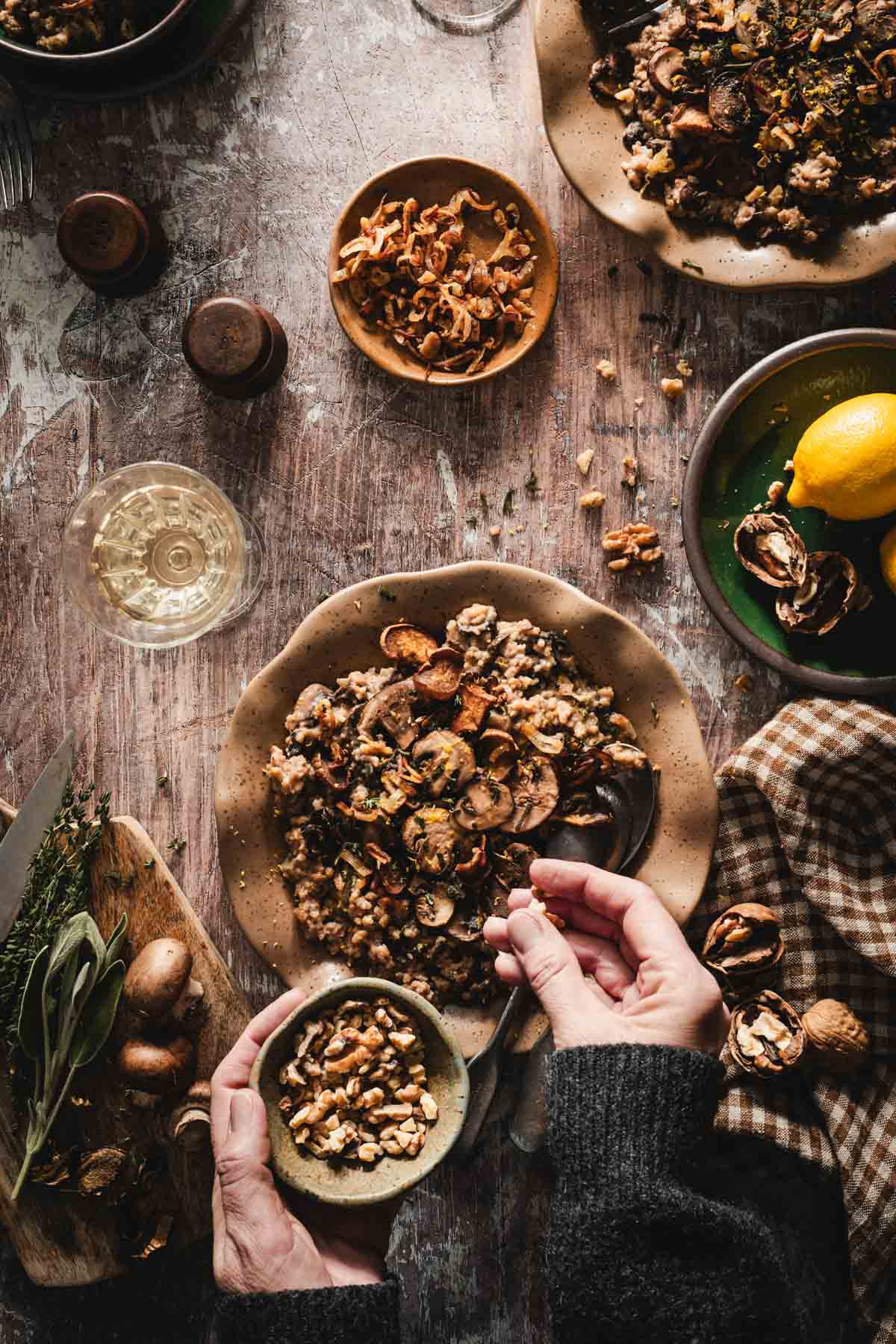 hands in frame adding nuts to the risotto