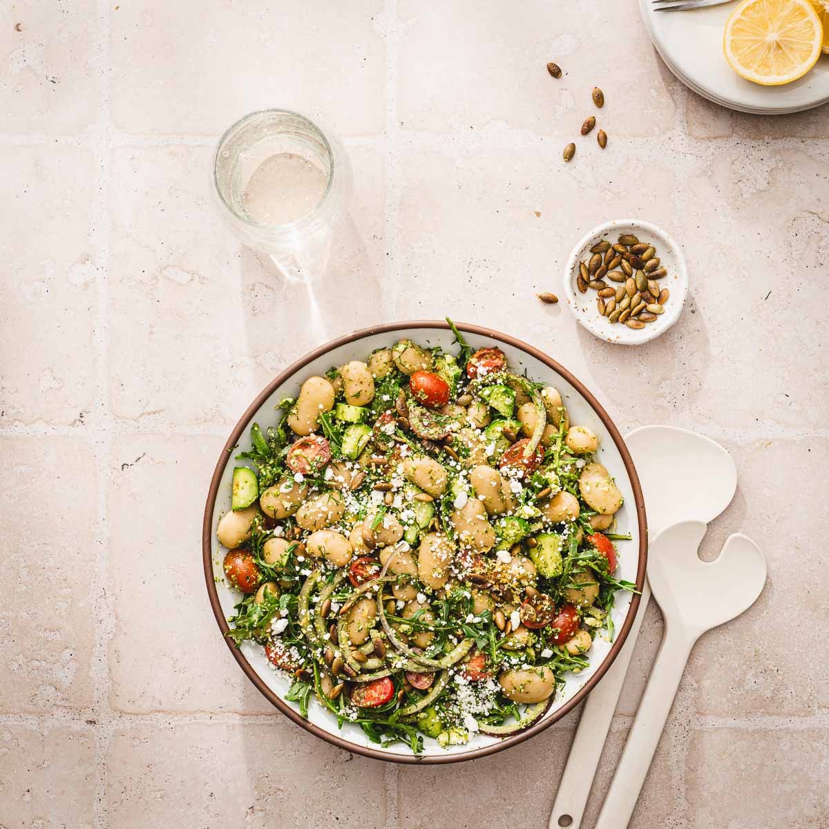 white bean slaad in a serving bowl, glass of wine