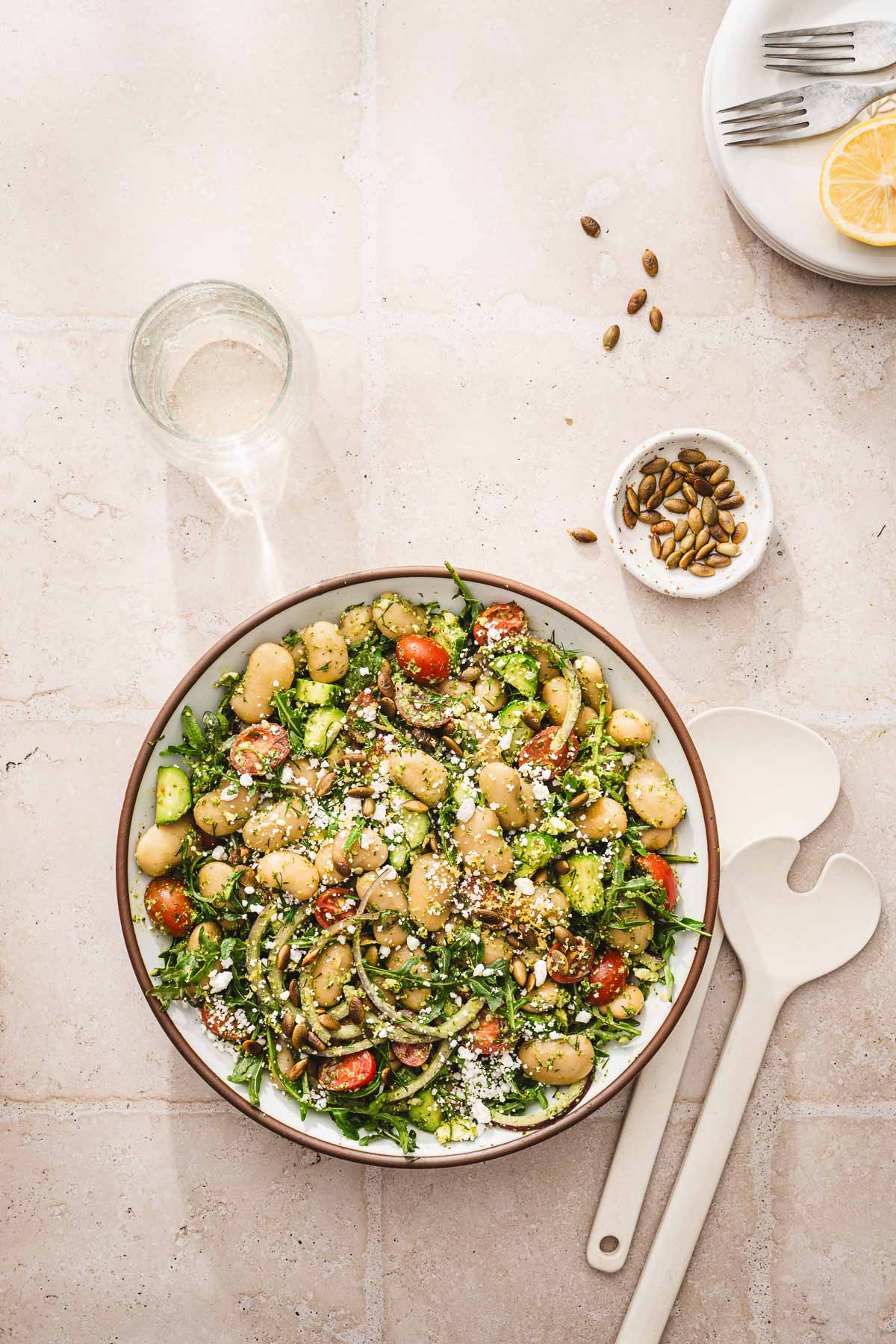 bowl with salad, plates, fresh lemon cut in half