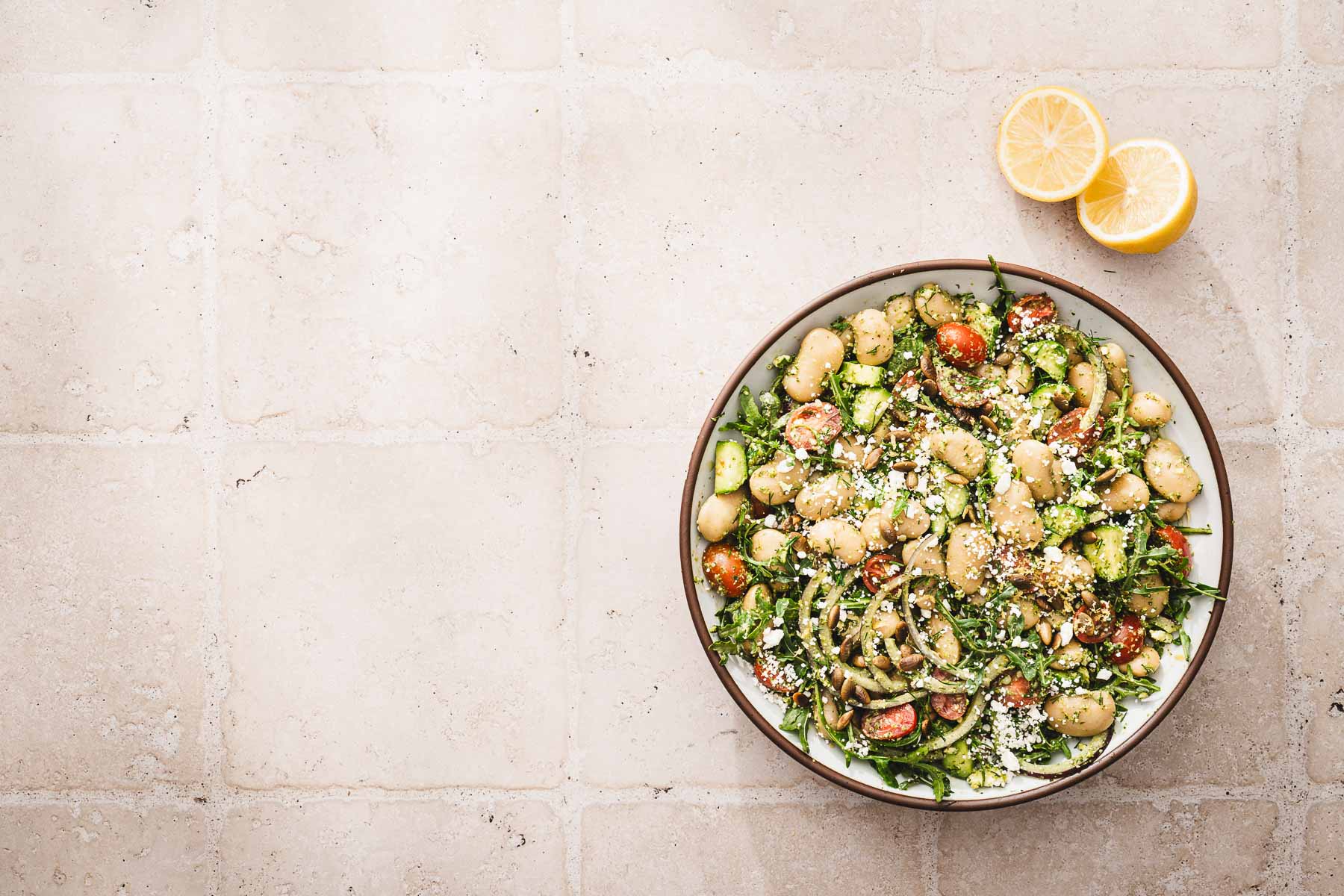 bowl with salad, fresh lemon cut in half