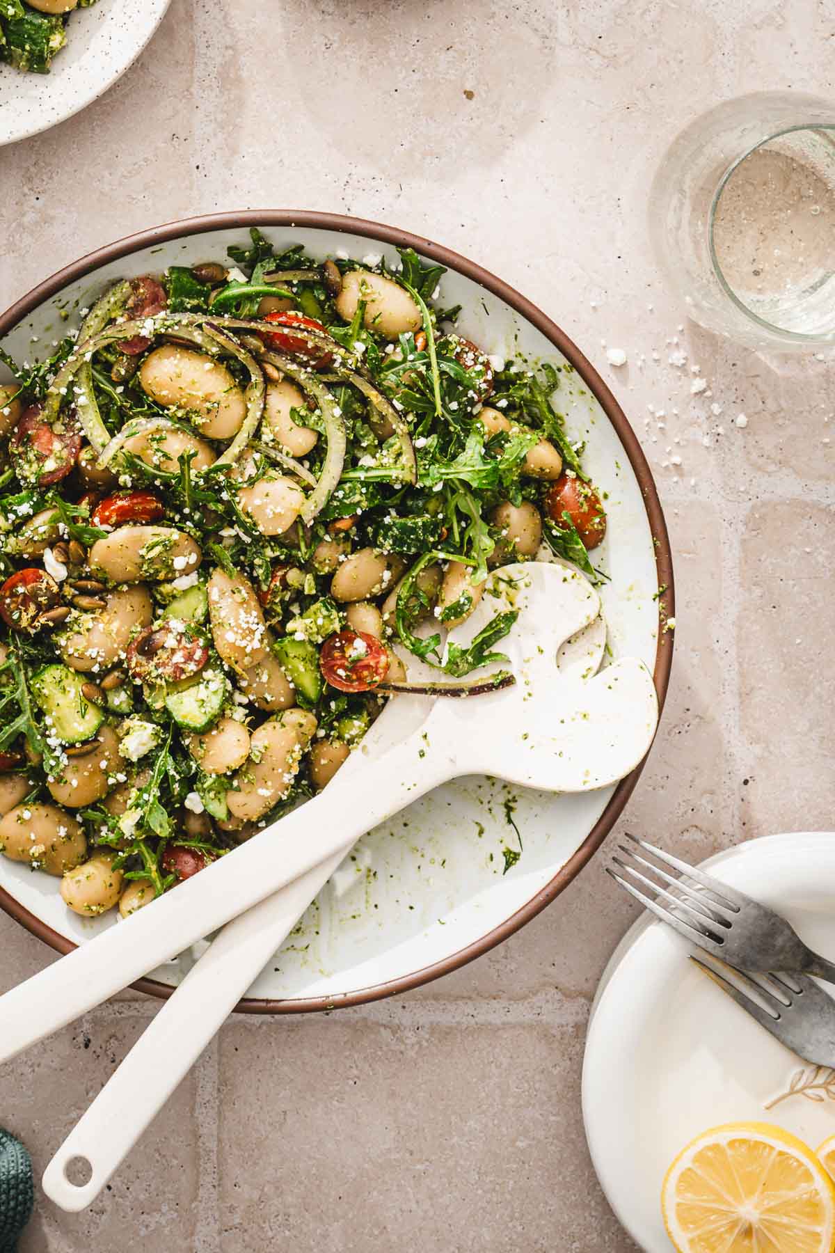 top view of a bowl with salad with serving utensils