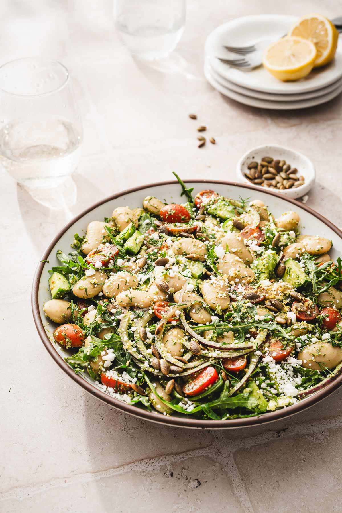 sid view of bowl with salad, glass with water