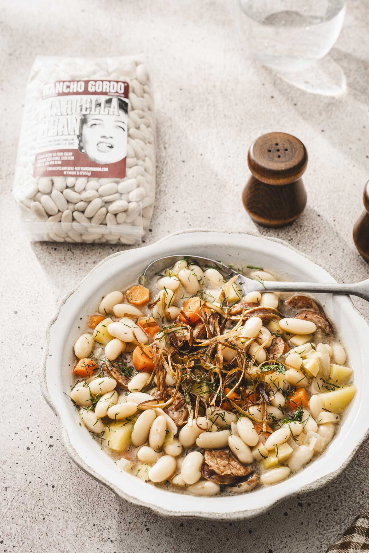 angle view of a bowl with soup, bag with beans in the background