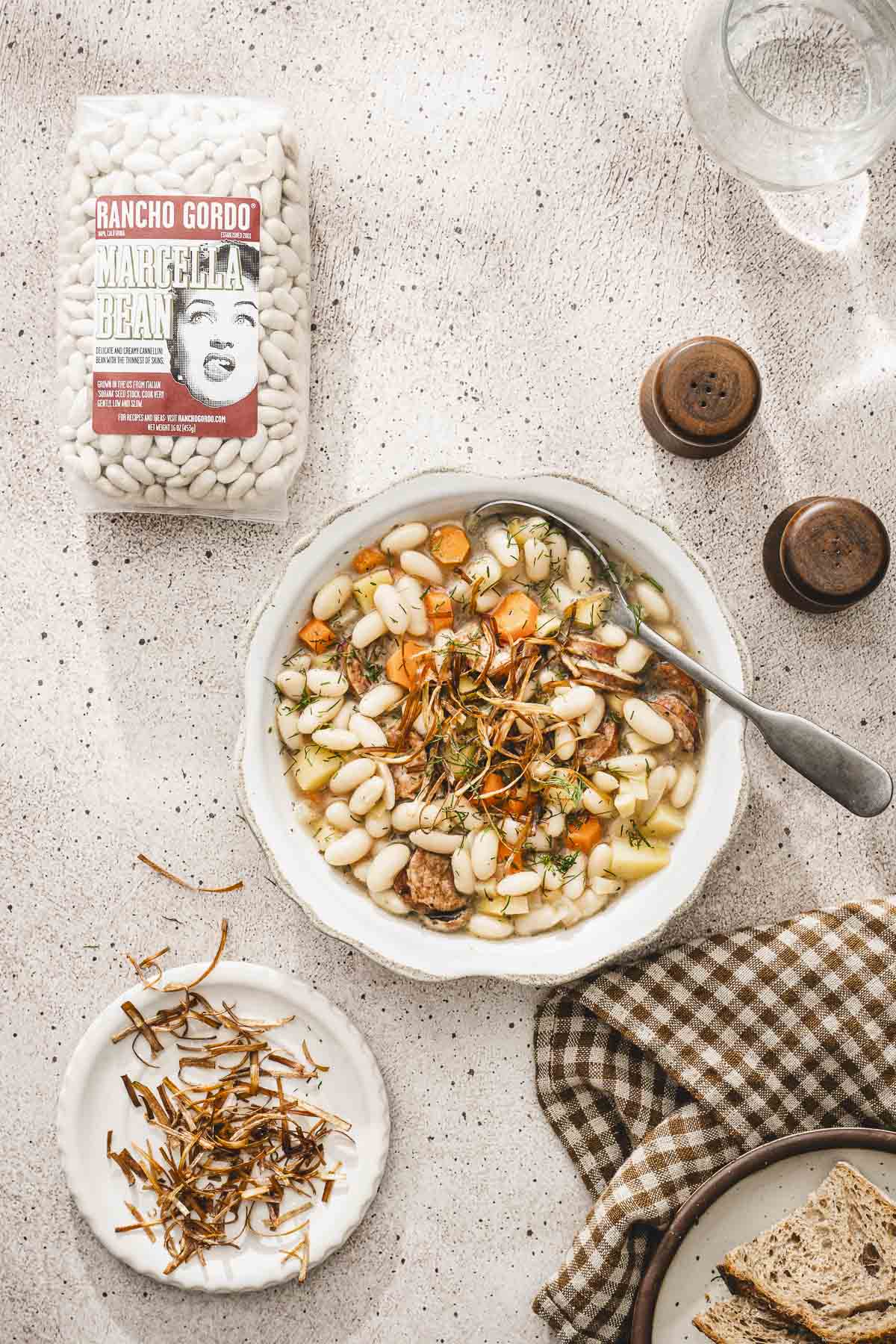 bowl with the soup, bag with raw beans, salt and pepper