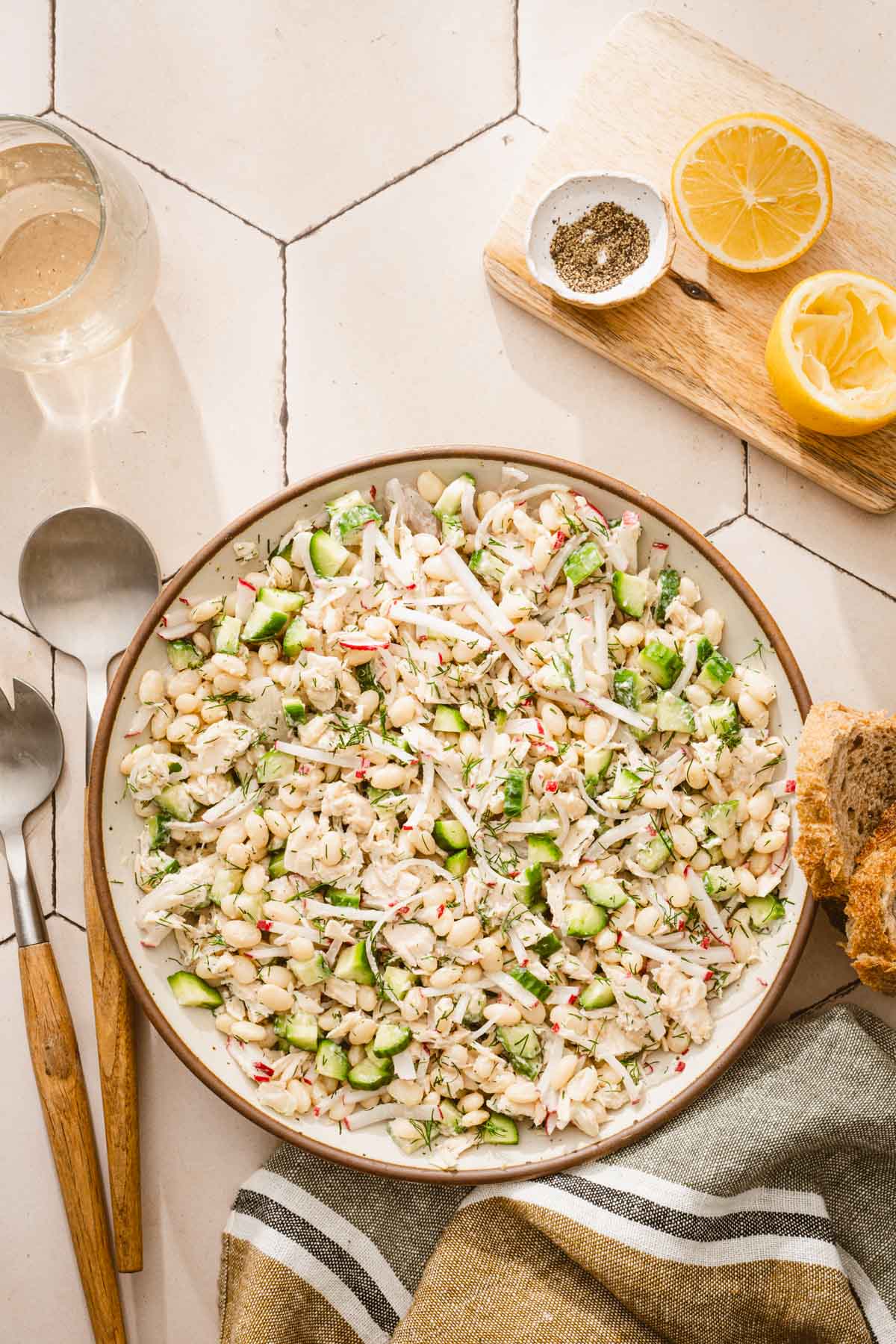top view of the bowl with salad, wooden board with lemons