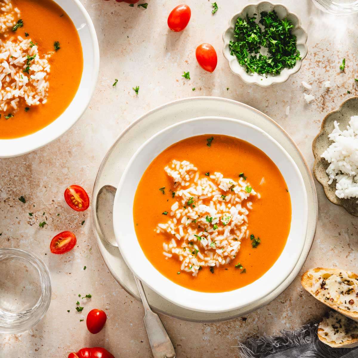 bowls with zupa pomidorowa, plate with rice, dish with parsley, cheesy toast