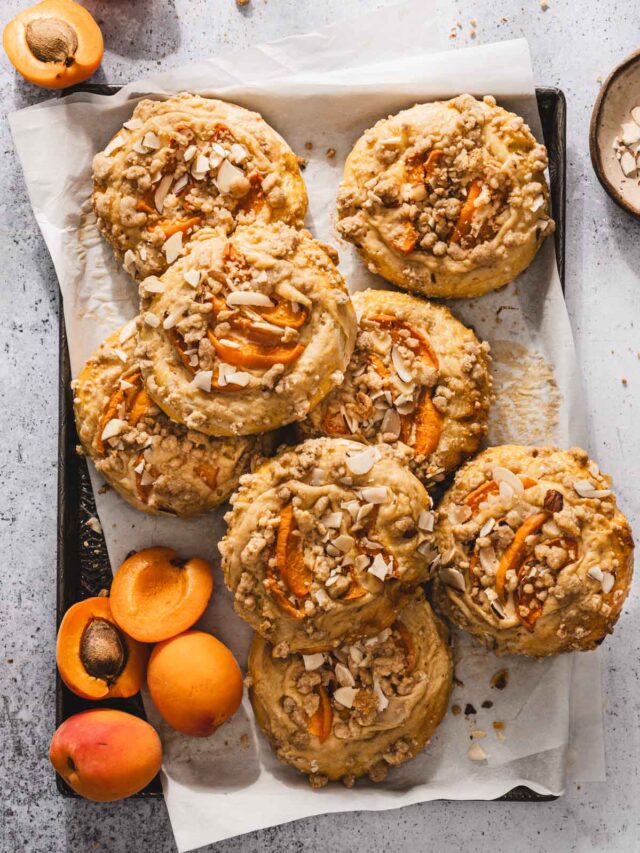 sweet buns on a baking sheet, fresh apricots