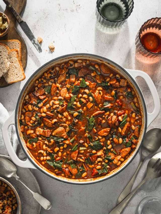 Black-Eyed Pea Stew in a saucepan, two glasses with water, slices of bread, serving utensils