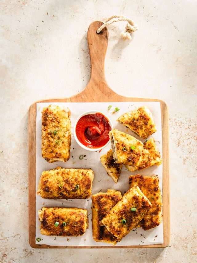 cooked krokiety on a cutting board with a ketchup for dipping