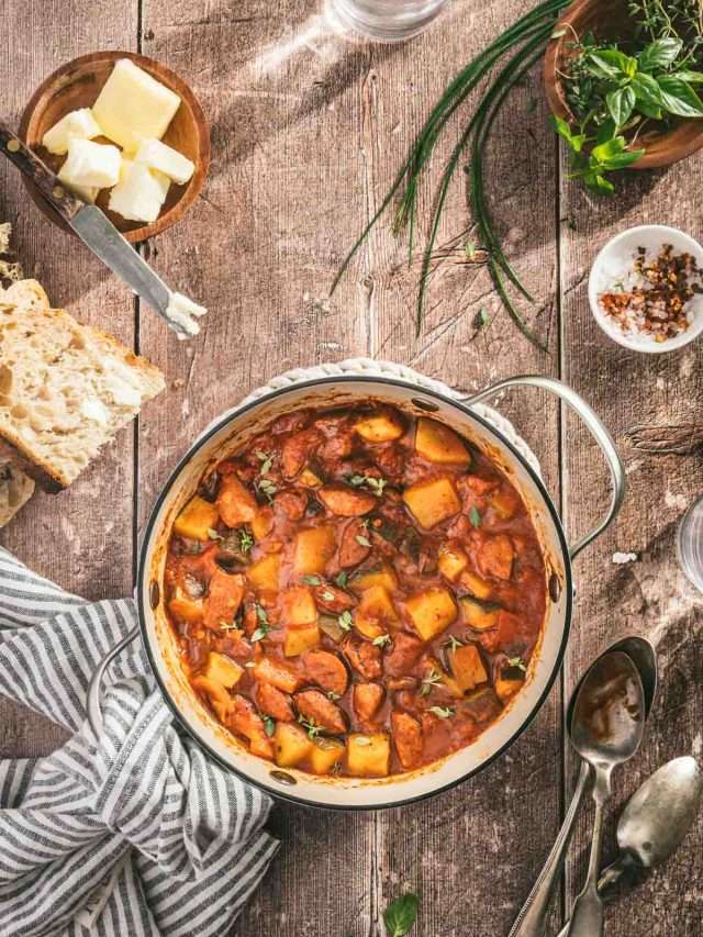 leczo in a pan, napkin, slices of bread, fresh herbs, spoons