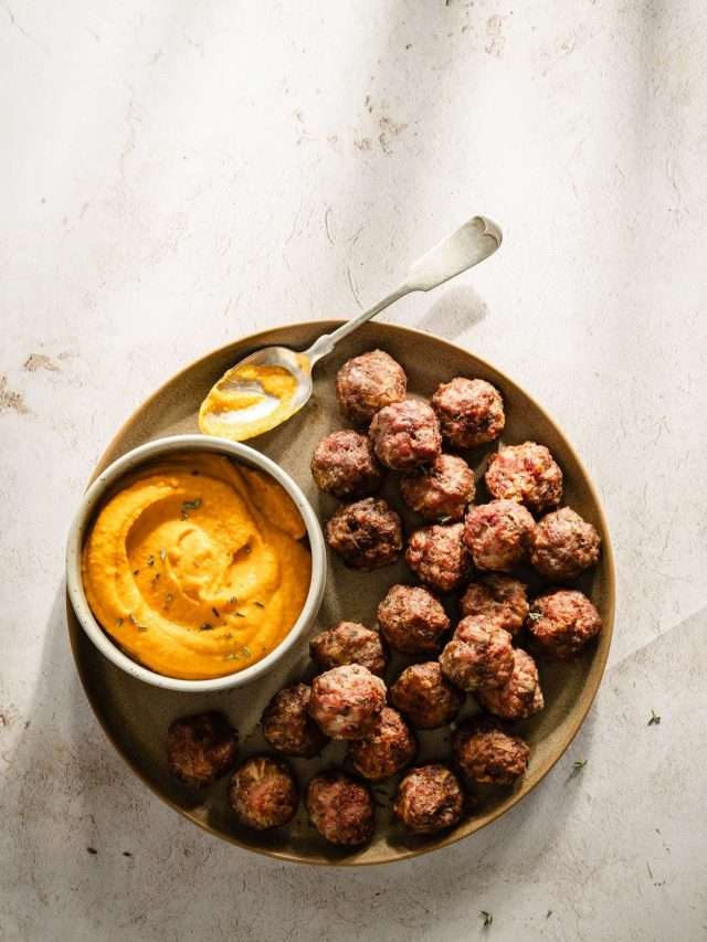 meatballs on a serving platter, dish with sauce and spoon