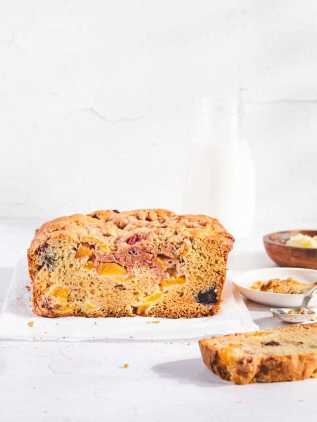 Peach bread front view, small dish with butter, honey, pecans, bottle with milk in the back