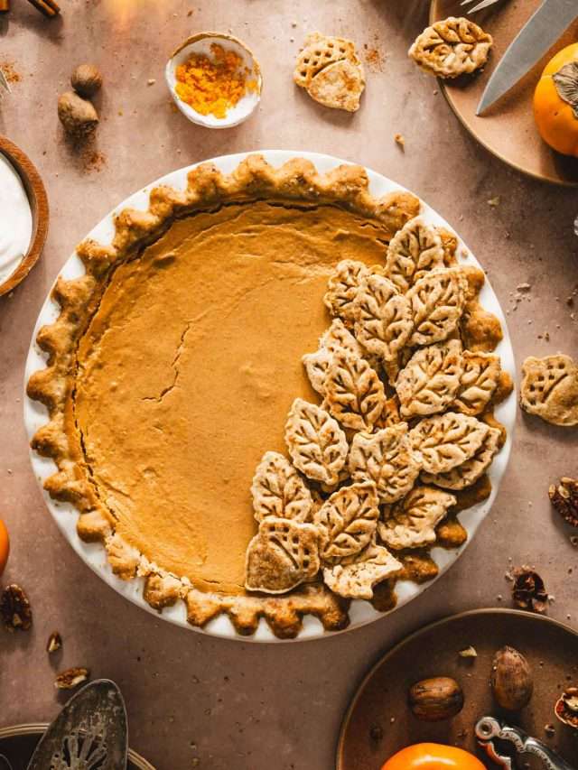 persimmon pie, serving plates, nuts, fresh fruit, glasses with tea, close up of the pie