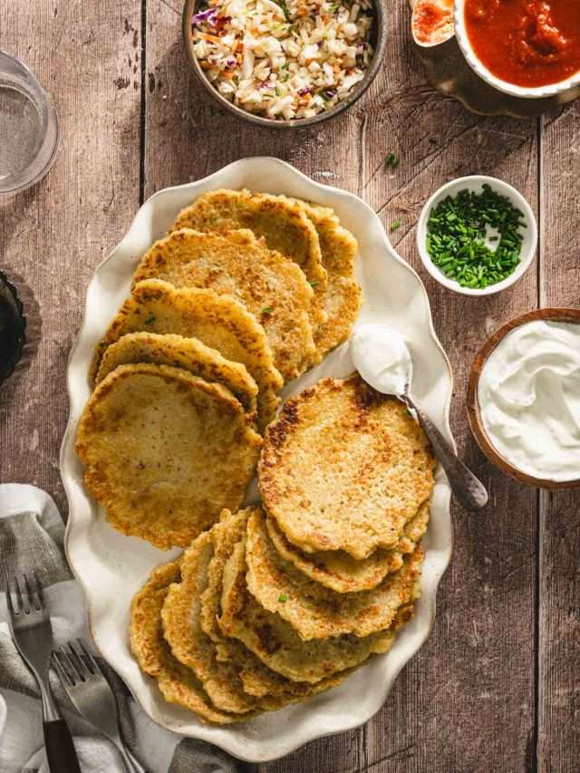 potatoes pancakes styled on a serving platter; small bowls and dishes with various garnishes